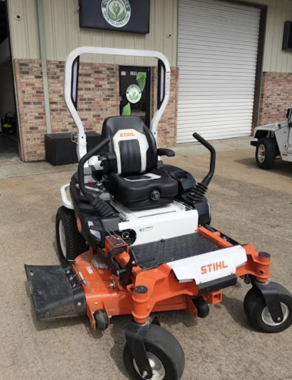 STIHL battery-electric zero-turn mower parked in front of the QuietScapes shop